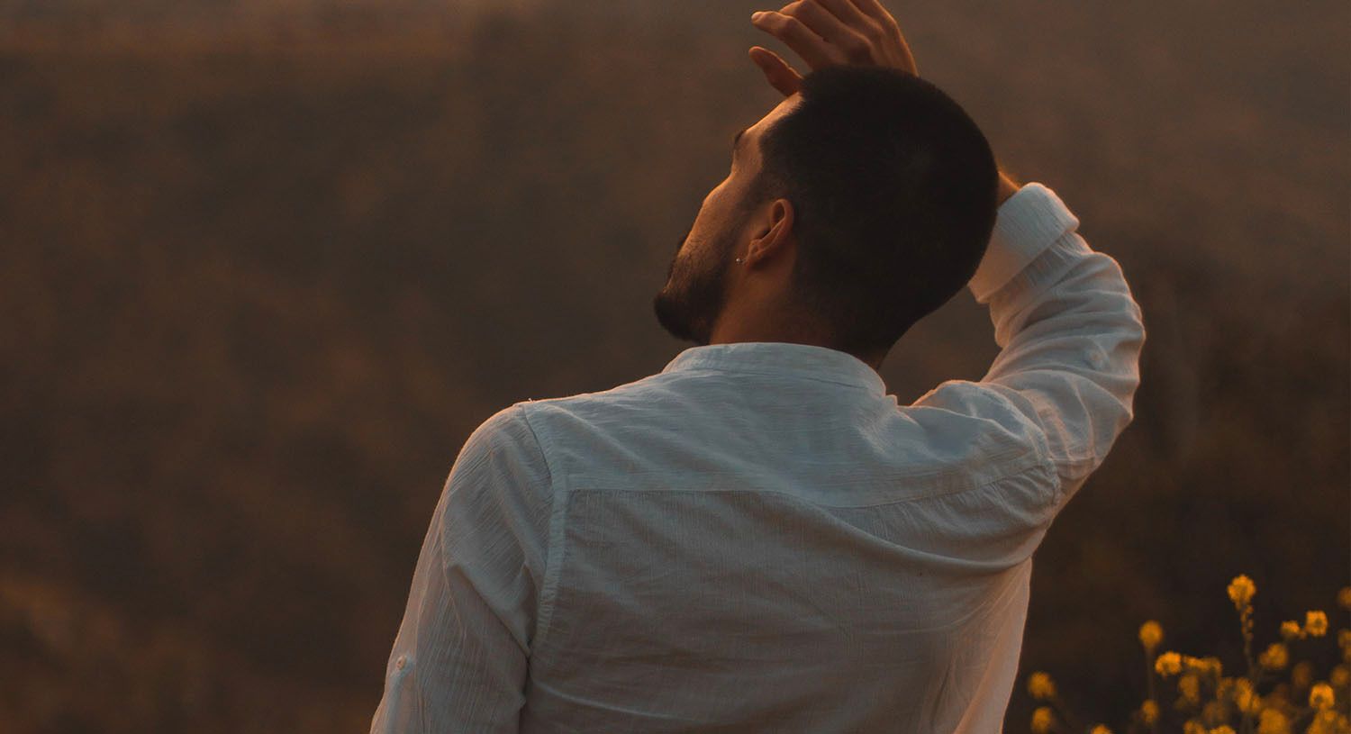 View from behind of a man with hand on his head