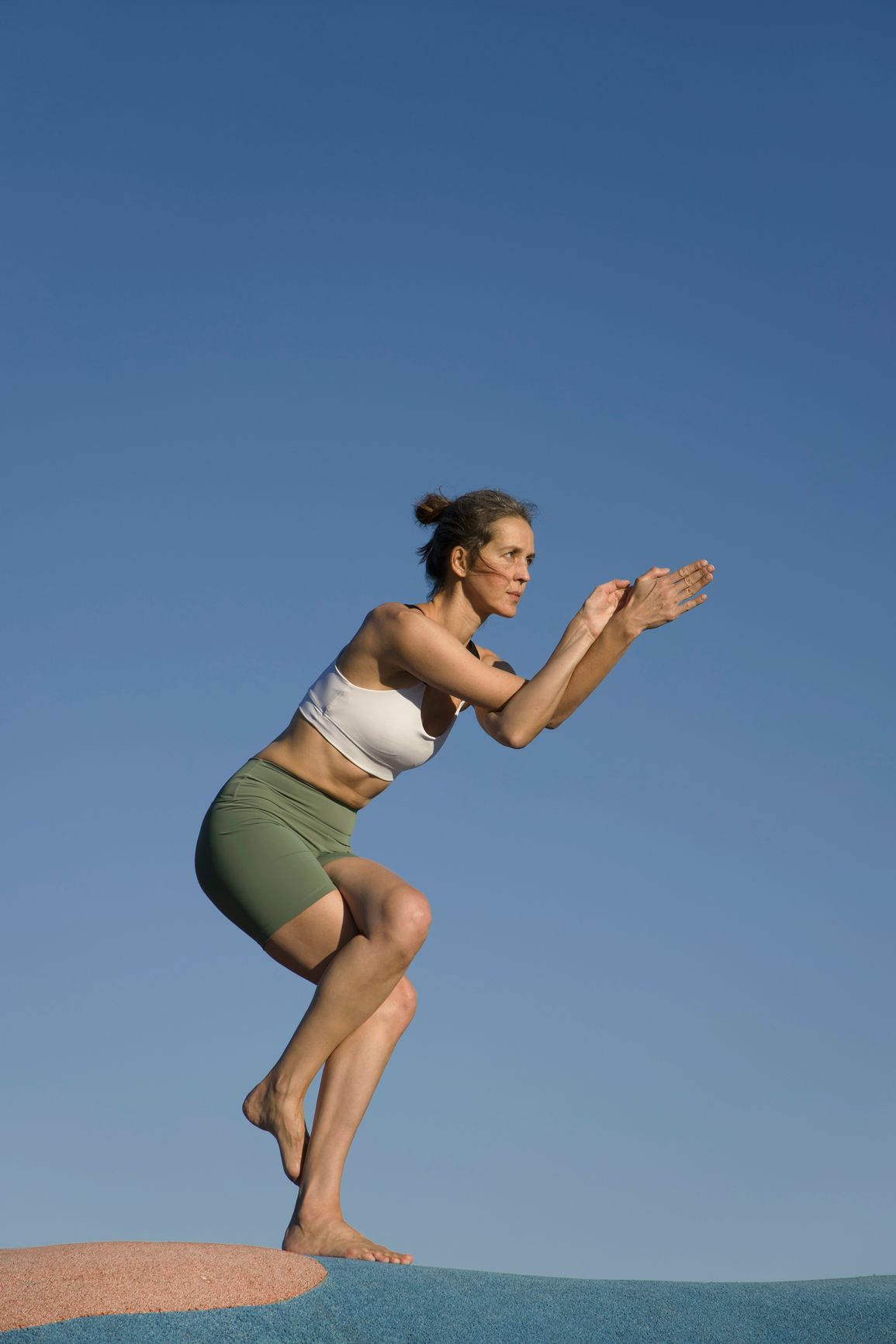 Woman in athletic clothes doing yoga on the beach