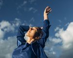 woman reaching hands up to clouds