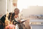 Guy Reading a Book on Balcony