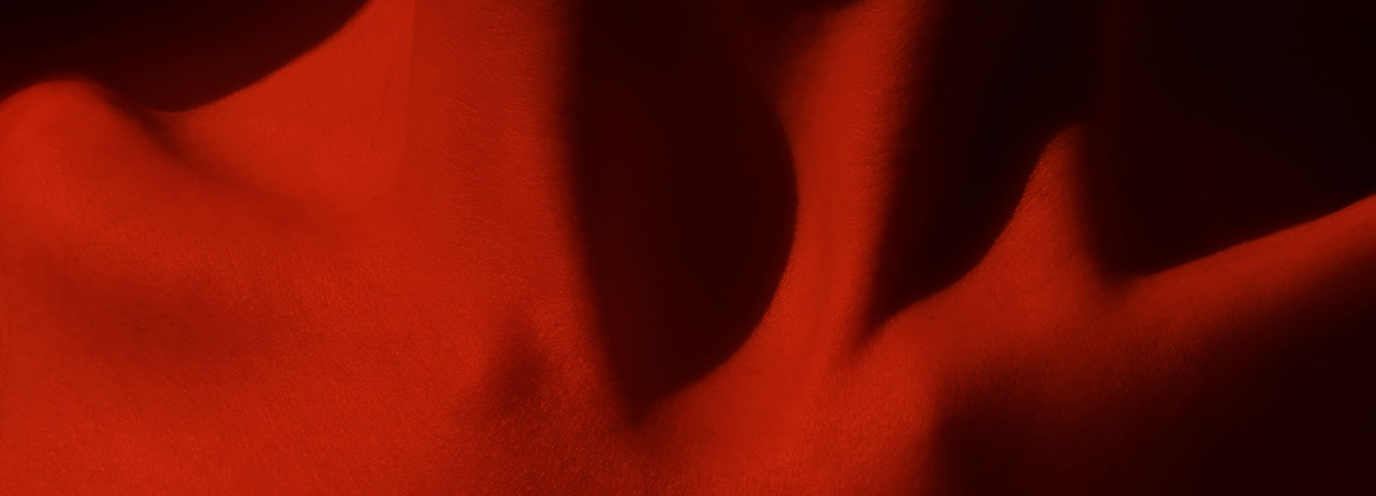 Close up of woman's clavicle with red light reflecting off the body