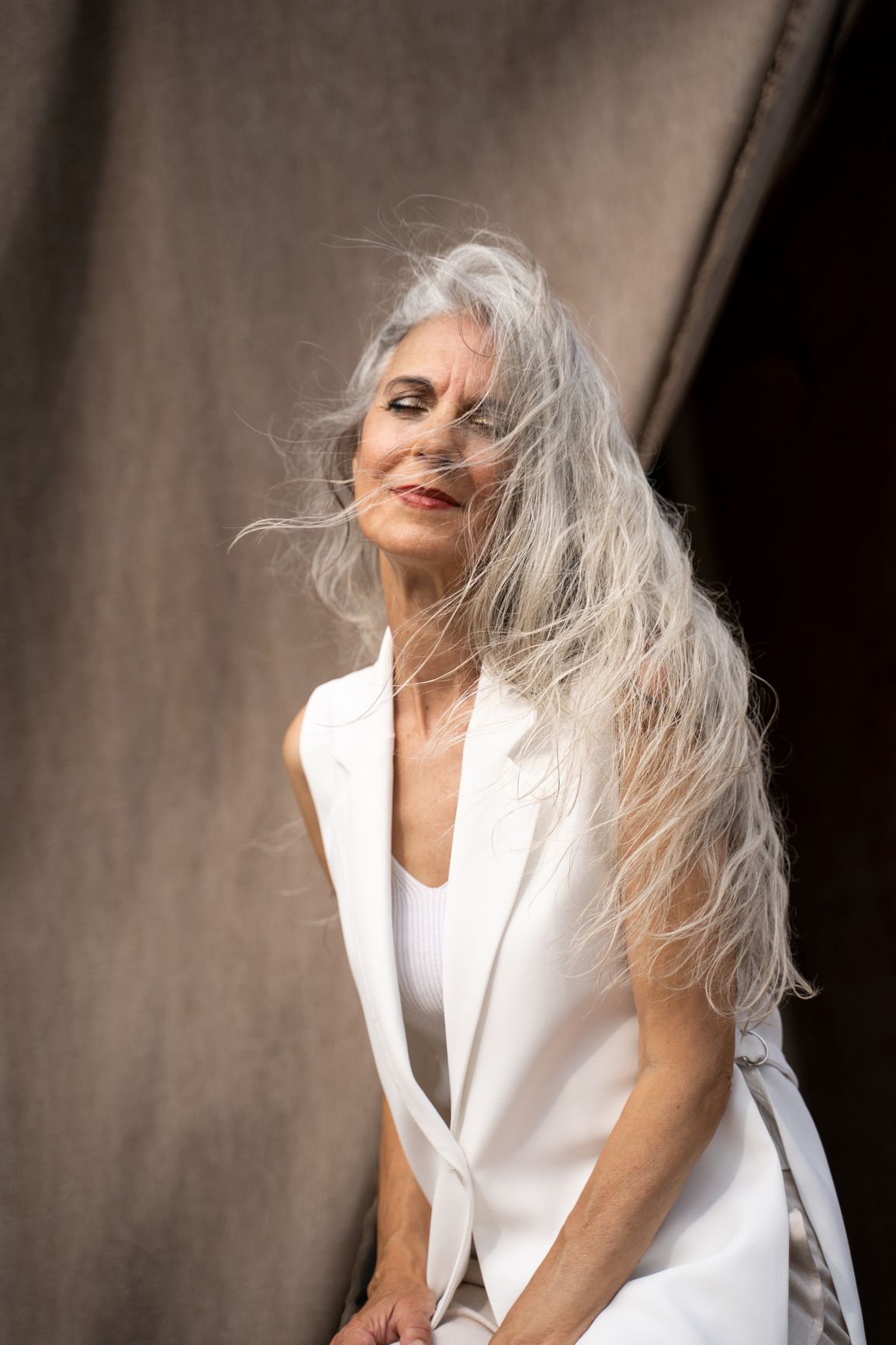 A woman in a white suit smiling