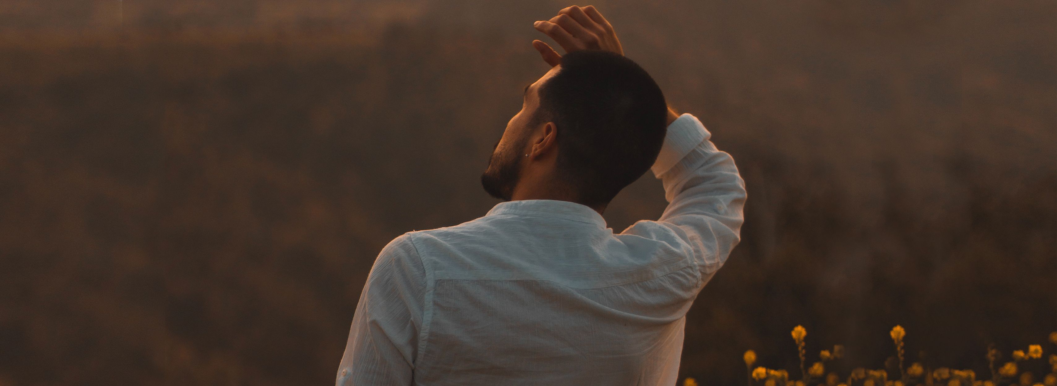 View from behind of a man with hand on his head