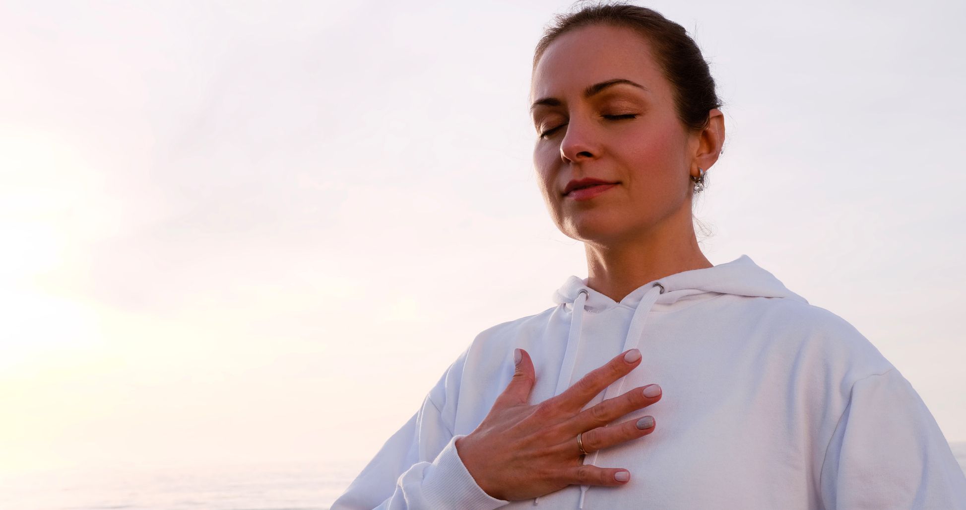 woman with hand over chest