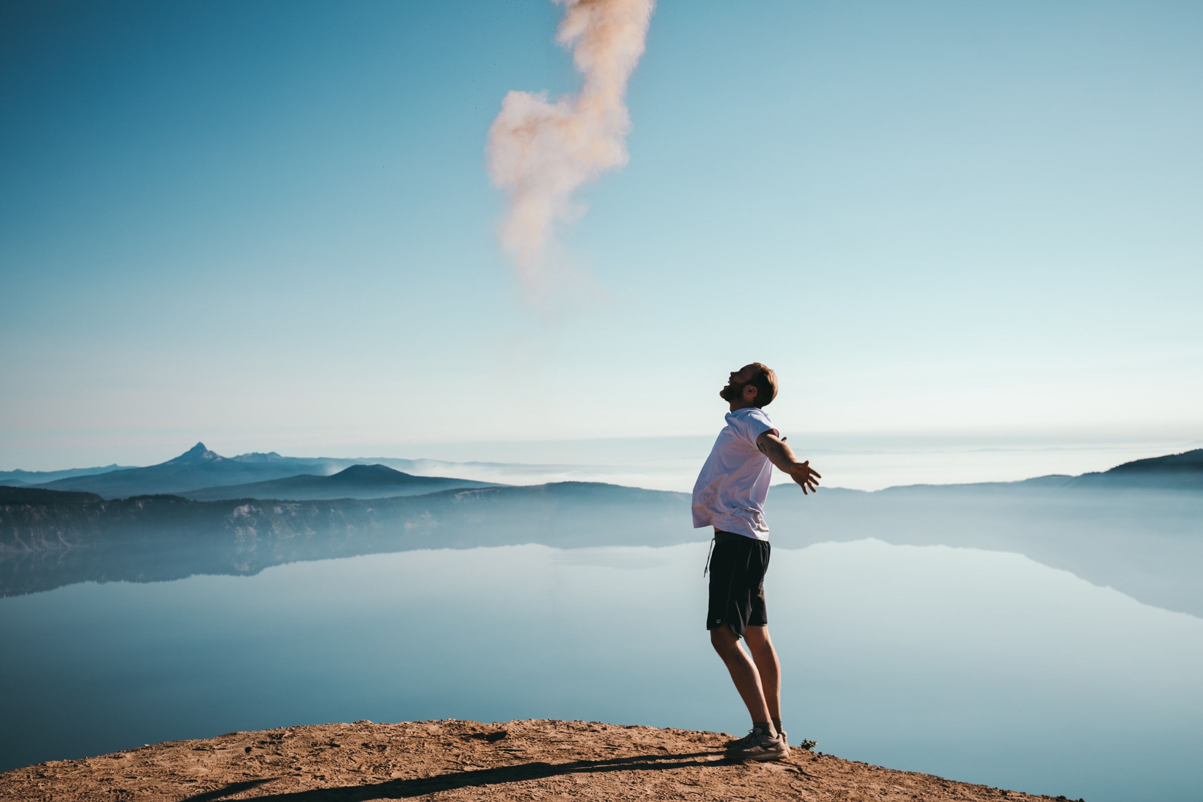 Guy on a cliff with arms outspread