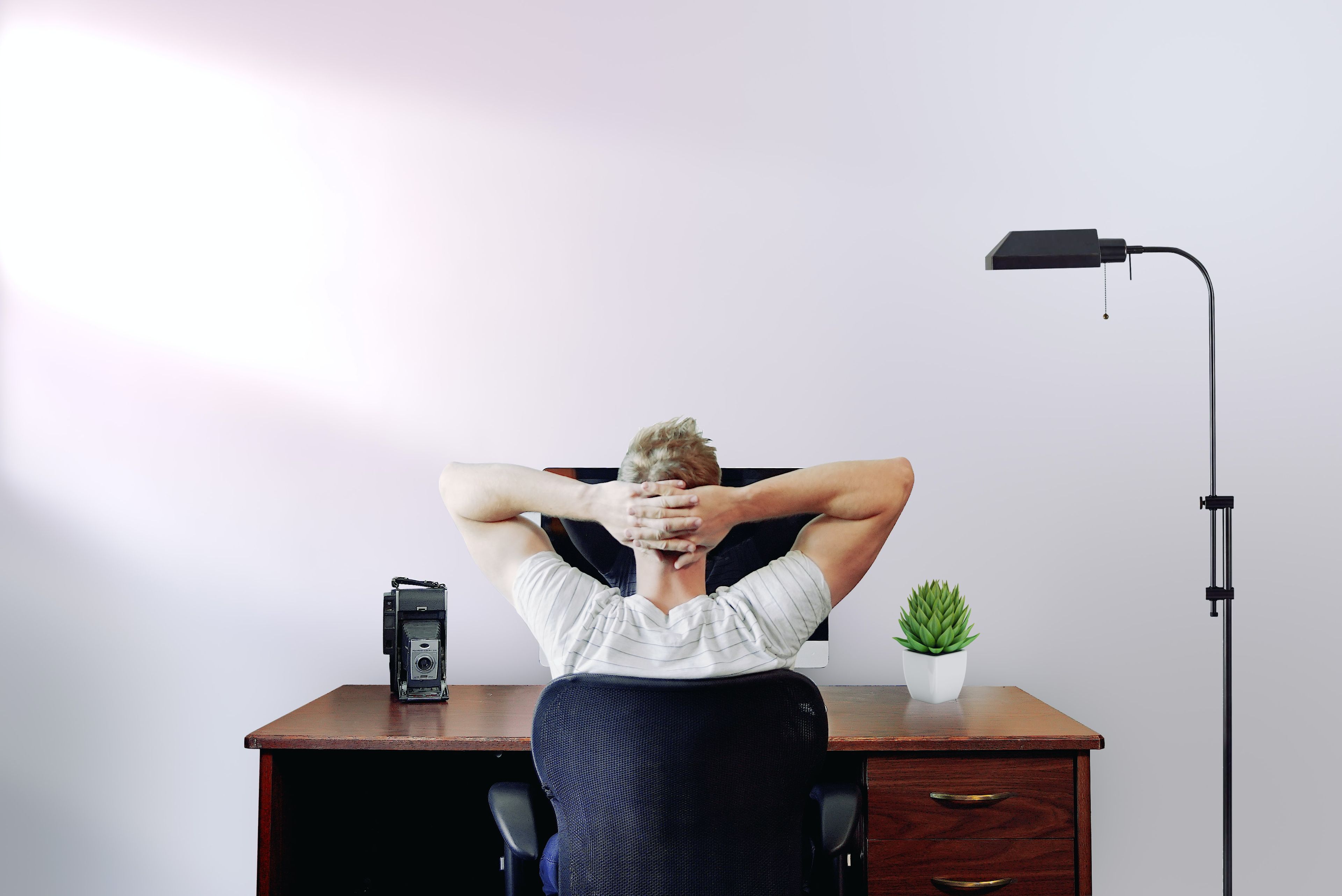 Guy sitting at desk with hands on his head