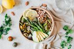 Bowl of veggies, tomatoes, avocado and grains.