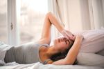 woman in bed looking distressed