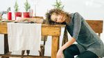 Tired woman leaning over table with holiday decorations