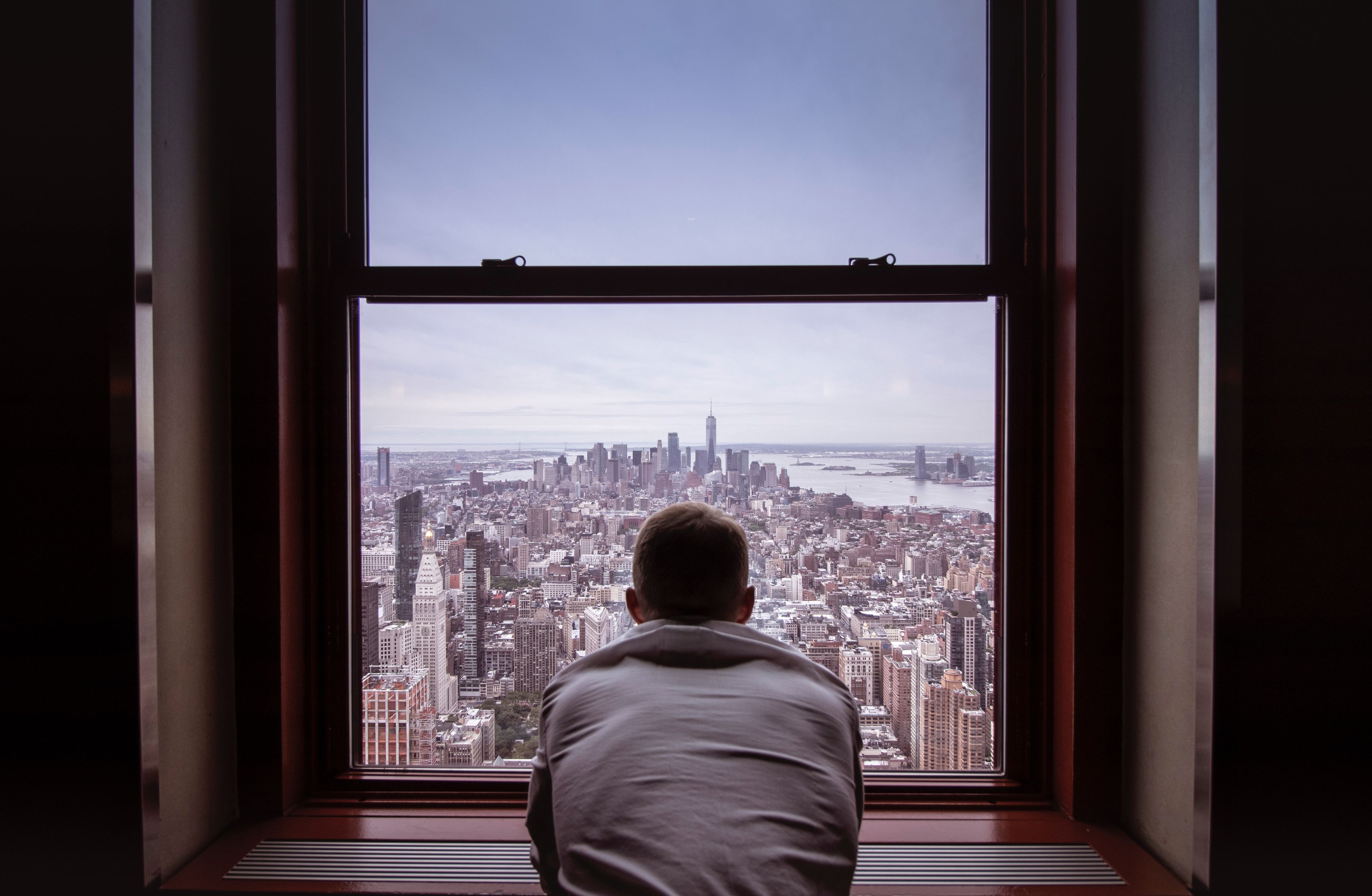 man looking out window nyc