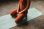 Woman sits on yoga mat