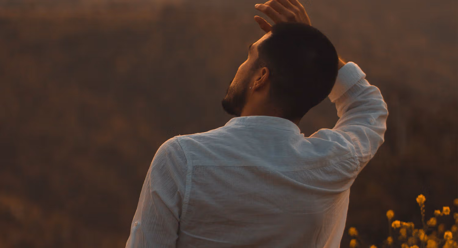 View from behind of a man with hand on his head