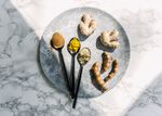 Spoons with spices and pieces of ginger and turmeric on platter