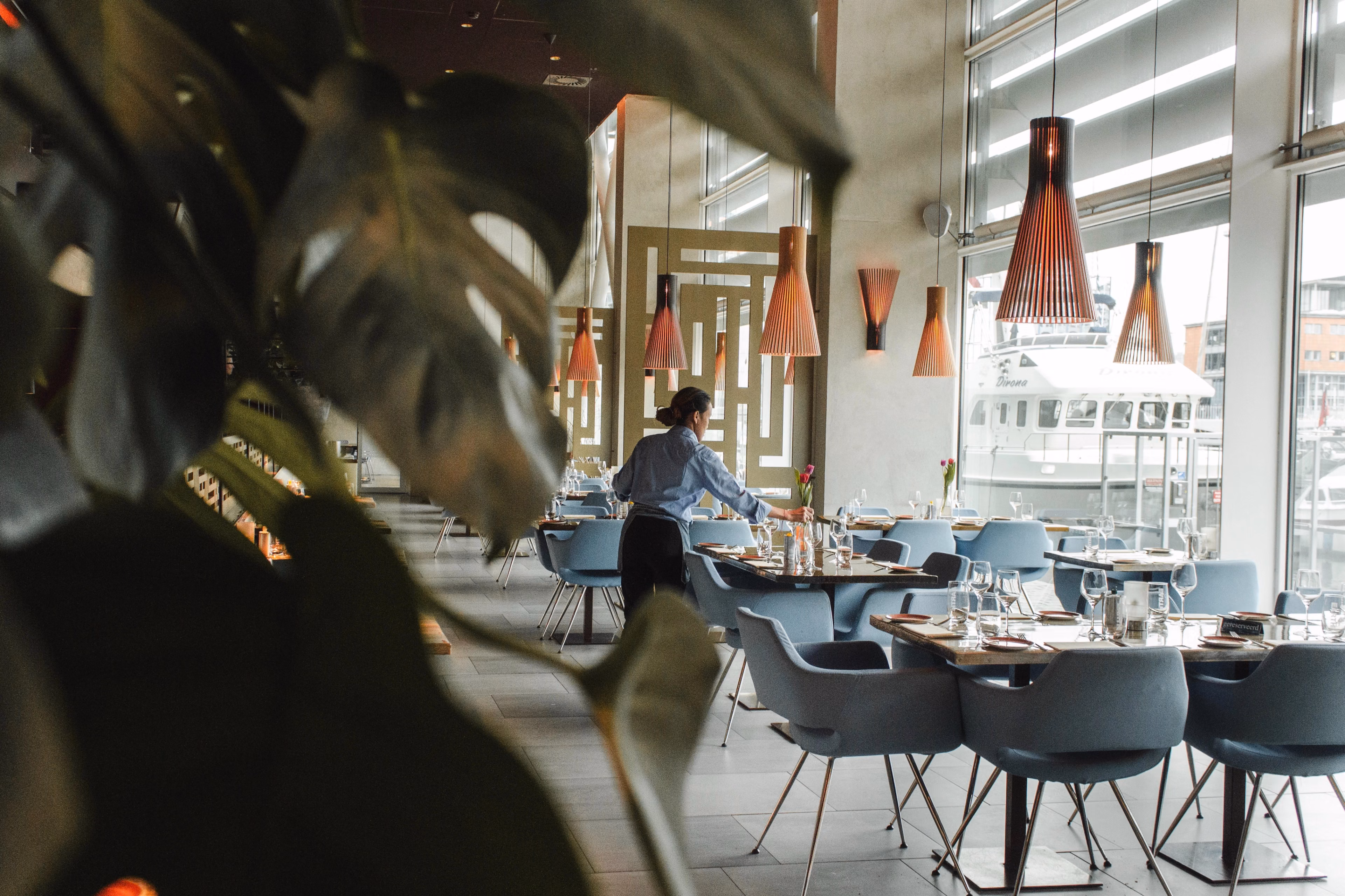 Server in an empty restaurant sets tables