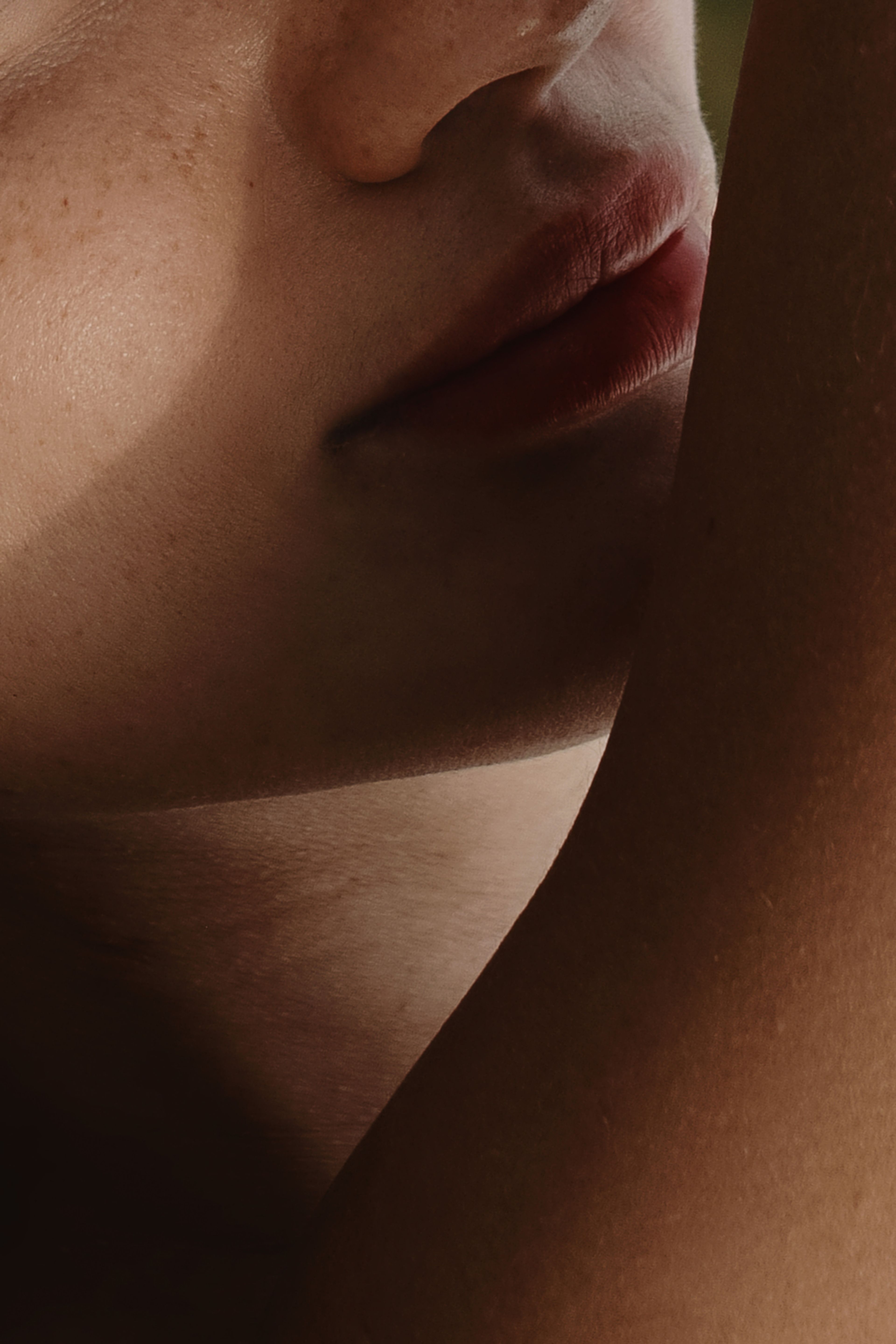 A close-up shot of a woman's face and arm