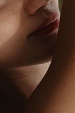 A close-up shot of a woman's face and arm