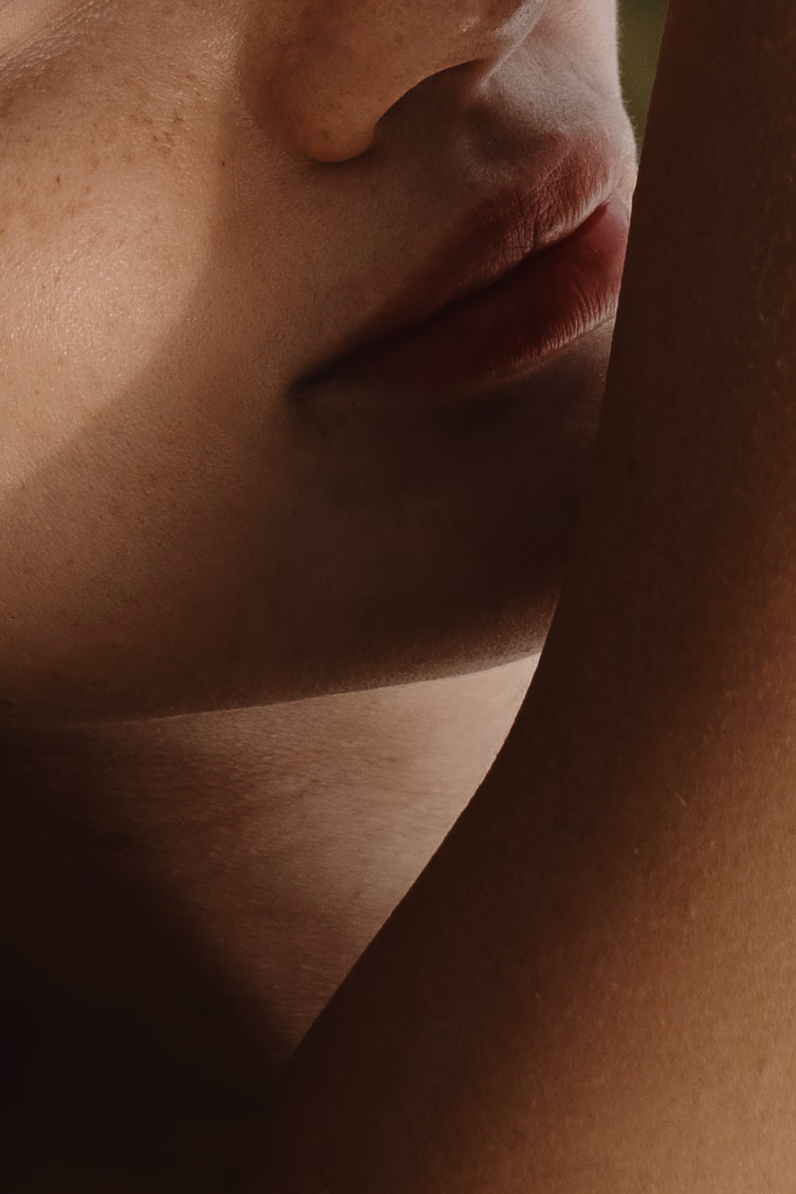 A close-up shot of a woman's face and arm