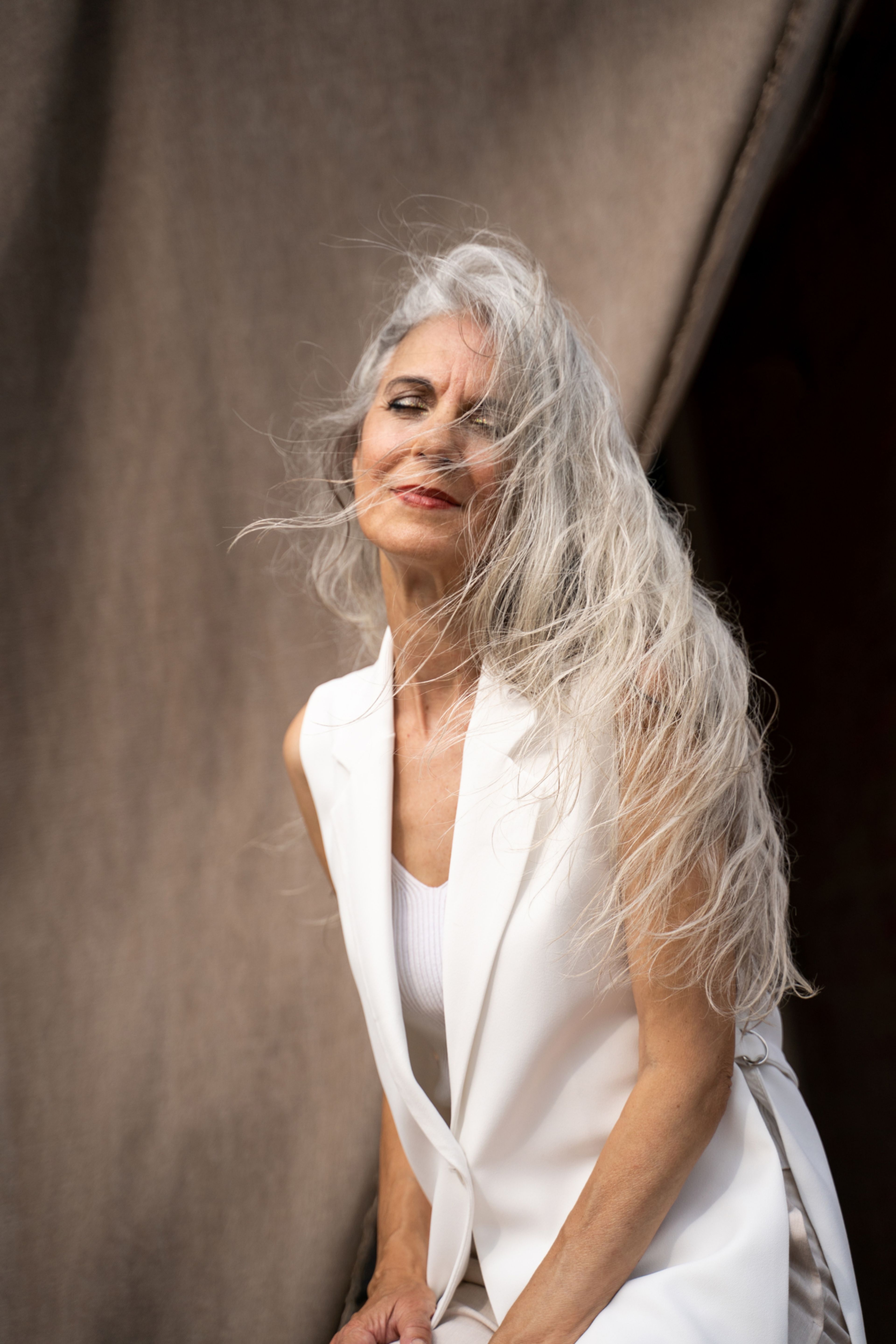 A woman in a white suit smiling