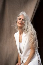 A woman in a white suit smiling