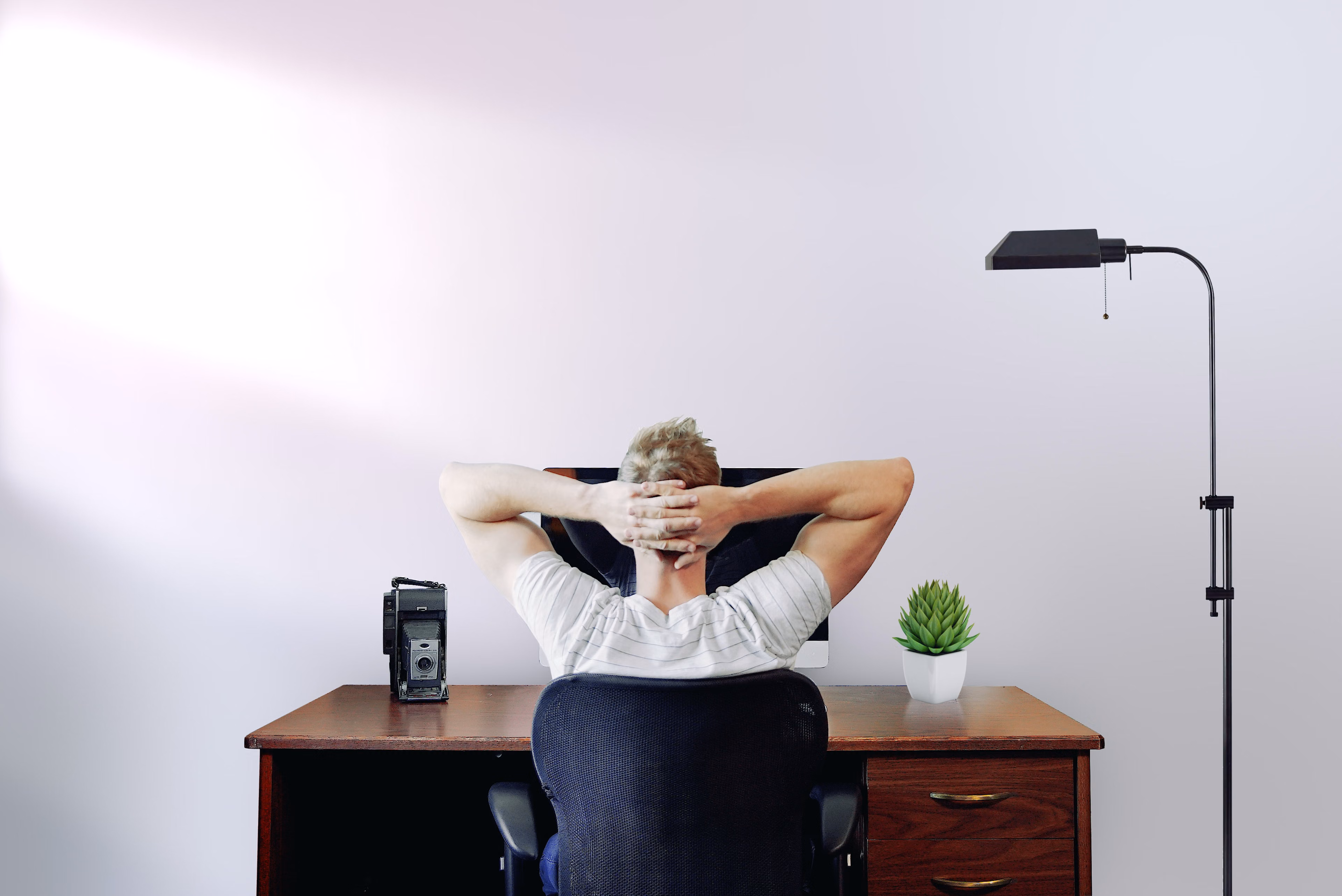 Guy sitting at desk with hands on his head