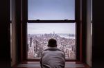 man looking out window nyc