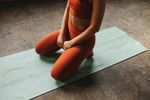 Woman sits on yoga mat